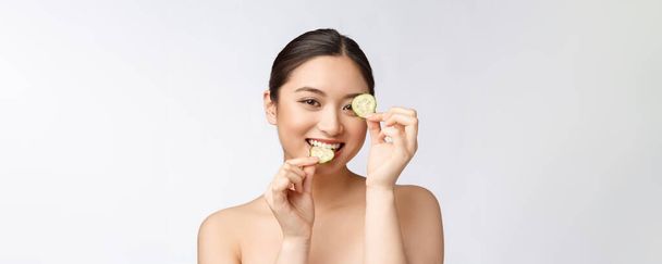 Natural homemade fresh cucumber facial eye pads facial masks. Asian woman holding cucumber pads and smile relax with natural homemade - Фото, зображення
