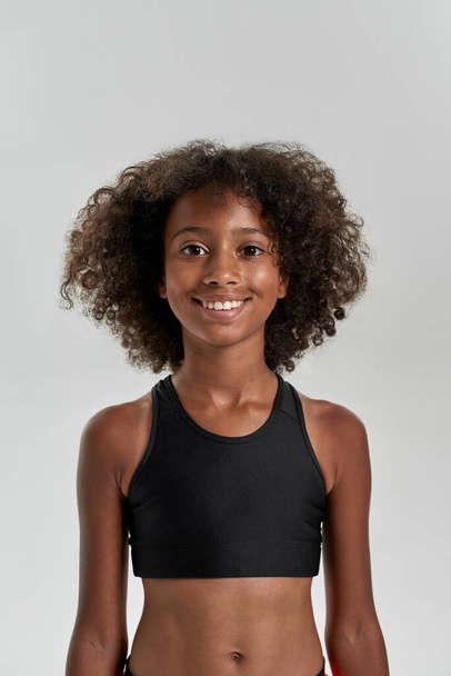 Front view of curly smiling girl looking at camera - Foto, afbeelding