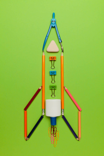 Spaceship (rocket) from stationery on green background. Child imagination, science in elementary school. (preschool) - Zdjęcie, obraz