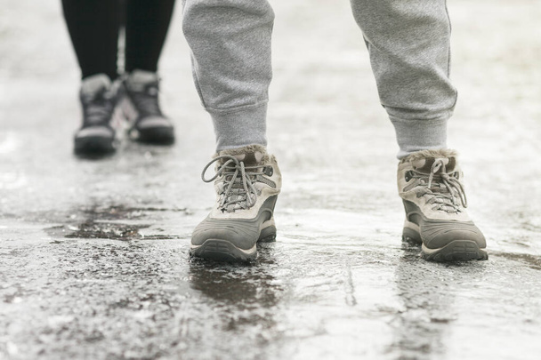 Pedestrians glide along the icy sidewalk. Winter ice on footpaths. - Photo, Image