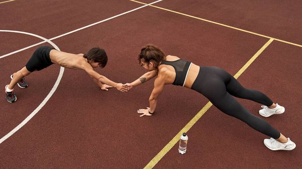 Woman with son do plank exercise and hold hands - Photo, image