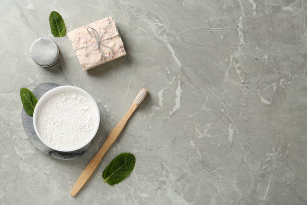Flat lay composition with tooth powder and mint on light grey marble table, space for text - Photo, Image