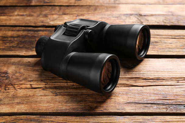 New binoculars on wooden table. Optical instrument - Foto, Imagen