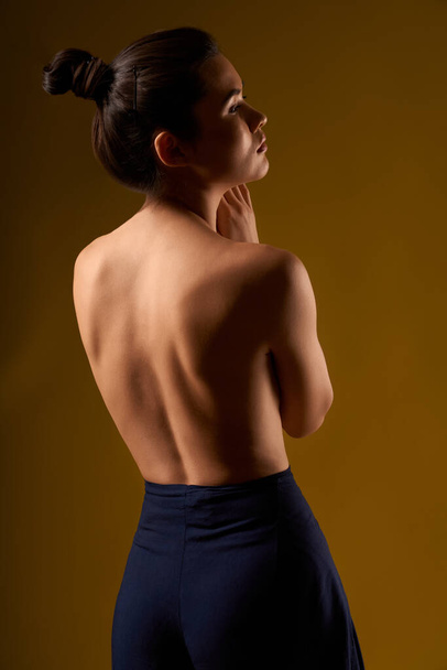 Female with bare back standing, looking forward. - Foto, Bild