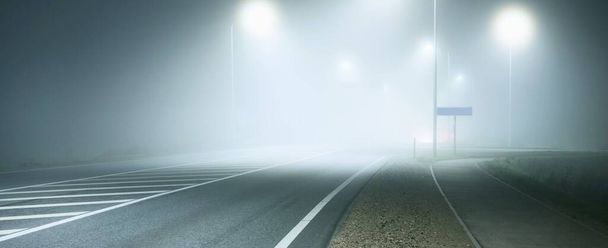 Vista panorâmica da nova estrada iluminada em um nevoeiro à noite, luzes de rua close-up. Luar. Cena urbana escura. A Europa. Transporte, logística, viagens, turismo, viagem rodoviária, liberdade, condução - Foto, Imagem