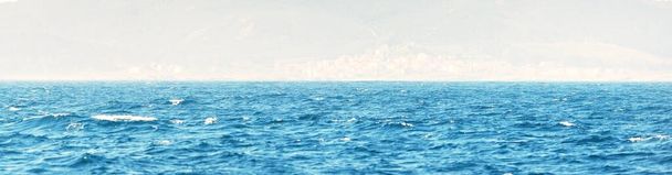 Средиземное море в солнечный день. Чистое небо. Текстура поверхности воды, волны, брызги. Синий, лазурный, бирюзовый цвета. Графические ресурсы, копировальное пространство. Панорамное изображение - Фото, изображение