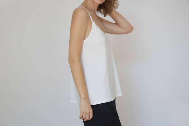 Woman in white cotton camisole shirt, studio shot. - Foto, Imagen