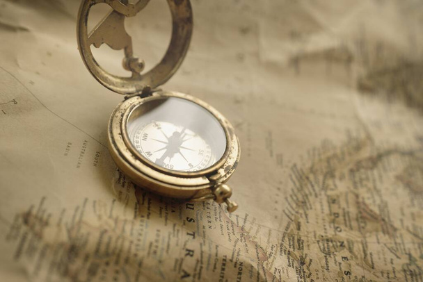Retro style antique golden compass (sundial) and old nautical chart close-up. Vintage still life. Sailing accessories. Wanderlust, travel and navigation theme. Graphic resources, copy space - Fotografie, Obrázek
