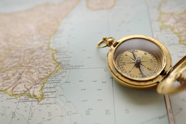 Retro style antique golden compass (sundial) and old nautical chart close-up. Vintage still life. Sailing accessories. Wanderlust, travel and navigation theme. Graphic resources, copy space - Foto, Imagen