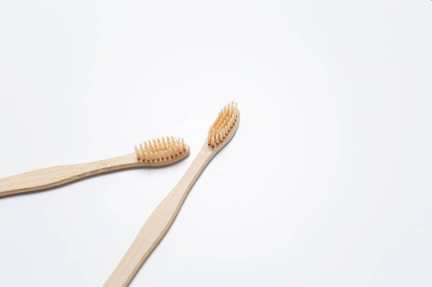 Close-up of two bamboo toothbrushes on white studio background. - 写真・画像