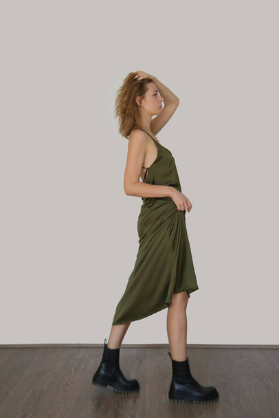 Студійна серія імпульсів молодої жінки в довгій зеленій шовковій сукні
   - Фото, зображення
