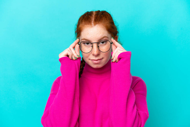 Junge rötliche Frau isoliert auf blauem Hintergrund Mit Brille mit glücklichem Gesichtsausdruck - Foto, Bild