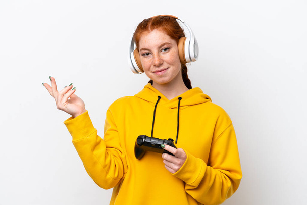 Beyaz arka planda izole edilmiş bir bilgisayar oyunu kontrolörüyle oynayan genç, kırmızı bir kadın davet edilmek için ellerini yana uzatıyor. - Fotoğraf, Görsel