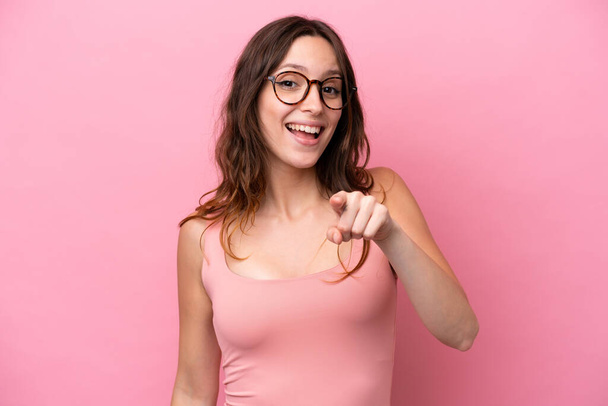 Молода біла жінка ізольована на рожевому тлі здивована і спрямована спереду
 - Фото, зображення