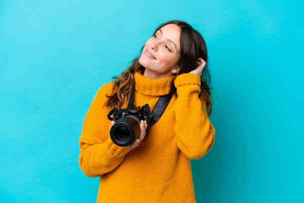 Young photographer woman isolated on blue background thinking an idea - Foto, imagen