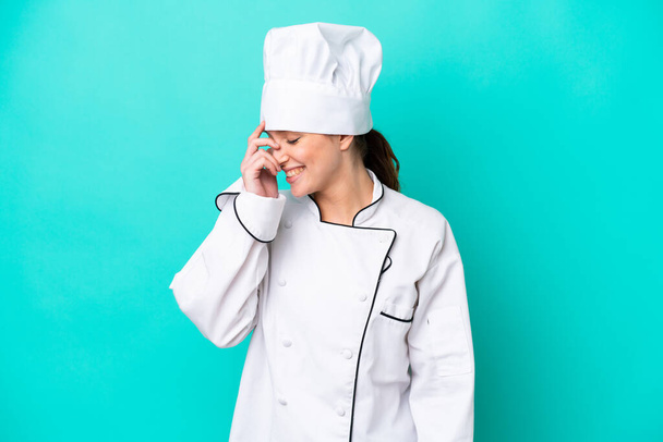 Young caucasian chef woman isolated on blue background laughing - Photo, Image