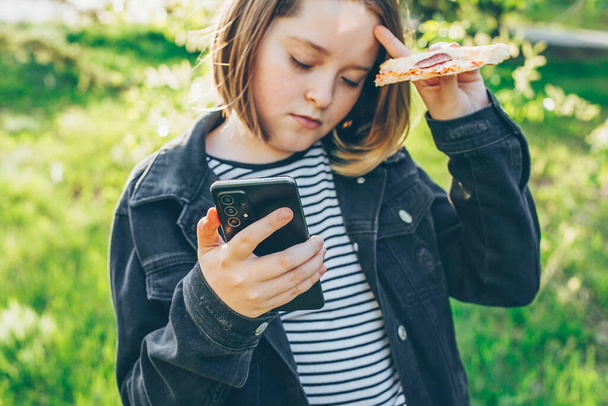 Preteen κορίτσι κρατώντας τηλέφωνο, χρησιμοποιώντας το κινητό τηλέφωνο για να συνομιλήσετε με τους φίλους. Έννοια της σύγχρονης τεχνολογίας - Φωτογραφία, εικόνα