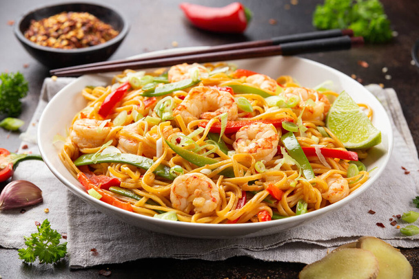 Stir fry noodles with prawns and vegetables in white plate. Healthy asian food - Foto, afbeelding