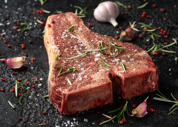 Raw T Bone beef steak with herb and seasoning on rustic background - Photo, image
