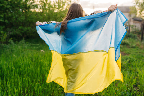 Girl with the flag of Ukraine. Free young girl with Ukrainian flag - Fotó, kép