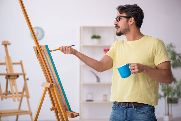 Νεαρός που απολαμβάνει τη ζωγραφική στο σπίτι - Φωτογραφία, εικόνα