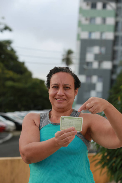 salvador, bahia, brazil - may 8, 2022: woman holding voter registration during electoral period in Salvador city. - Photo, Image