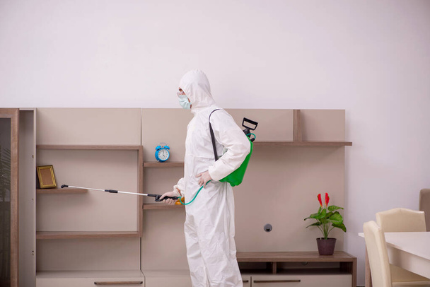 Joven contratista masculino haciendo control de plagas en casa - Foto, Imagen
