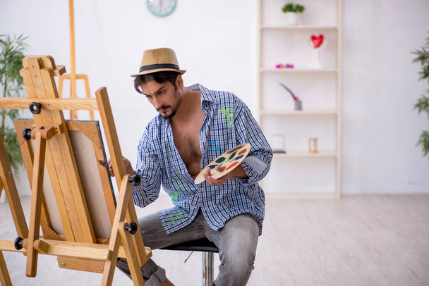 Νεαρός που απολαμβάνει τη ζωγραφική στο στούντιο - Φωτογραφία, εικόνα