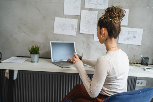 одна жінка молода біла жінка сидить за столом на роботі в офісі навчальні документи розслабляються під час роботи на ноутбуці реальні люди копіюють простір жінка-інженер студентський проект планування
 - Фото, зображення