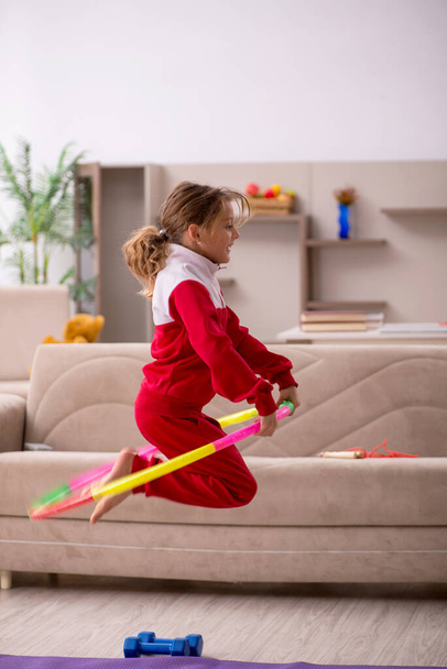 Маленькая девочка занимается спортом дома - Фото, изображение