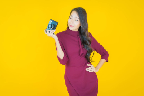 肖像美しい若いアジアの女性は、色の背景にカメラを使用 - 写真・画像