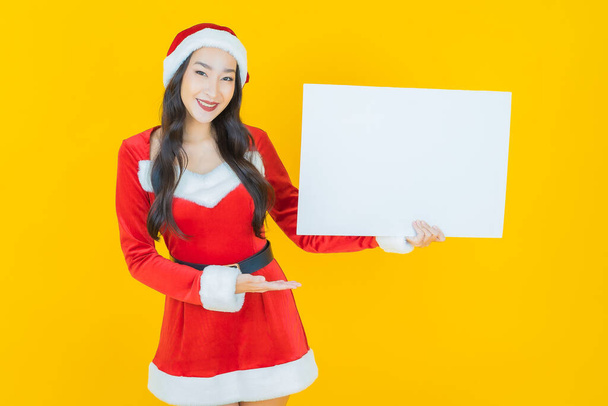 Güzel bir Asyalı kadın portresi. Arka planda beyaz bir pano olan bir Noel kostümü giyiyor. - Fotoğraf, Görsel