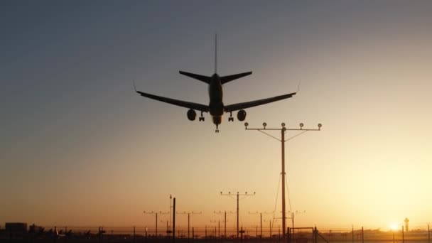 Repülőgép repül a feje felett, leszállás a repülőtér naplemente vagy napkelte, Cinematic utazás - Felvétel, videó
