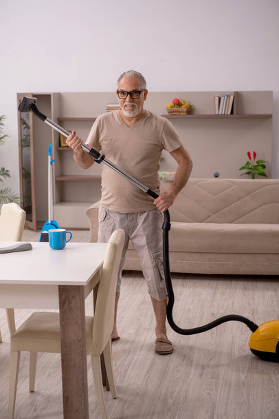 Vecchio che fa i lavori domestici a casa - Foto, immagini