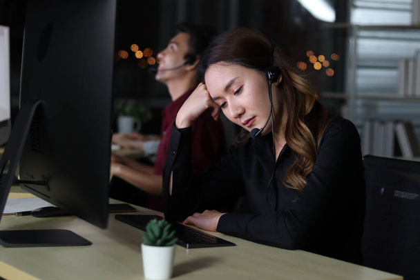 Call center azjatycki kobieta personel ze słuchawkami pracy w call center usługi konsultant coraz zdenerwowany, ponieważ klienci narzekają, praca w nocy uczucie smutku, zmęczony i wyczerpany, nieszczęśliwy koncepcji pracownika - Zdjęcie, obraz