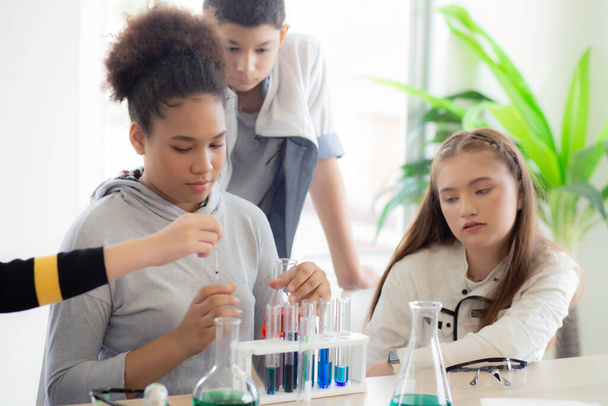 学校の研究室で液体のための科学とテスト化学についての若い教師グループの学生を教える,研究室で実験科学を勉強し、学習子供,教育の概念. - 写真・画像