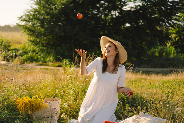 Szczęśliwy beztroskie lato dziewczyna na świeżym powietrzu pole z owoców brzoskwini pomarańczowej. - Zdjęcie, obraz