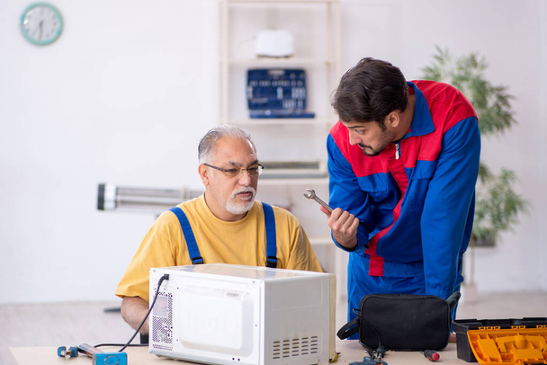 Dos reparadores masculinos trabajando en el taller - Foto, Imagen