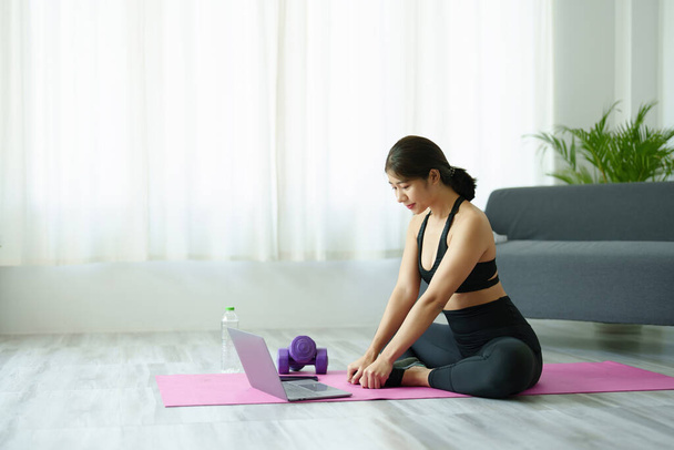 soulagement du stress, relaxation musculaire, exercices respiratoires, exercice, méditation, portrait de la jeune femme asiatique relaxant son corps du travail de bureau en pratiquant le yoga en regardant des tutoriels en ligne. - Photo, image