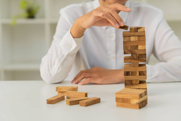construction alternative ideas Business plans and strategies The Risks of Building a Business Growth Idea with a Wood Block Picture of a businessman's hand placing a wooden block on a tower. - Foto, Imagem