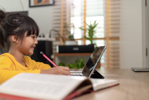 Азиатская девочка берет класс он-лайн и счастлив для Homeschool карантин Coranavirus пандемия концепции - Фото, изображение
