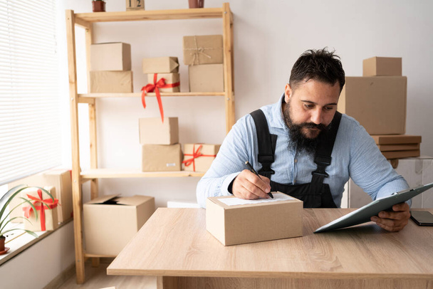 Start up entrepreneur of indian millennial man with box for packaging order from shopping online working at home office, small business owner making order delivery, small business shipping concept - Foto, Imagen