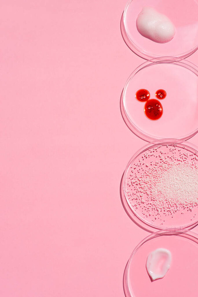 Cosmetic swatches. Appearance of the texture of the cream, red mask, foam and granules in petri dish on a pink background. Natural skincare products. Beauty concept for face and body care - Valokuva, kuva