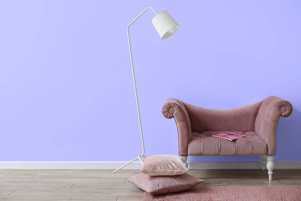 Sofa, lamp and cushions near lilac wall - Valokuva, kuva