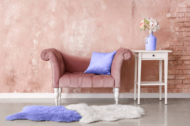 Стильний диван і стіл біля бежевої стіни
 - Фото, зображення