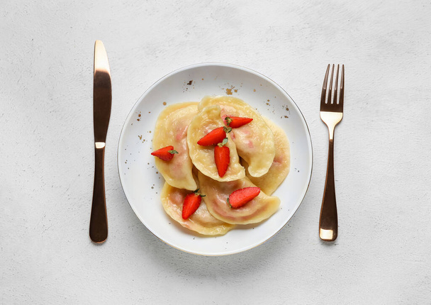 Μπολ με νόστιμα ζυμαρικά φράουλα και μαχαιροπήρουνα σε ελαφρύ φόντο - Φωτογραφία, εικόνα