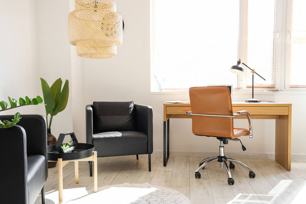 Інтер'єр сучасного офісу з робочим місцем і чорними кріслами
 - Фото, зображення
