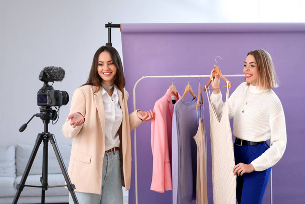 Młode blogerki modowe z modnymi ubraniami nagrywanie wideo w studio - Zdjęcie, obraz