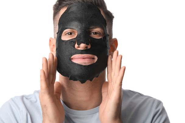 Schöner Mann mit schwarzer Gesichtsmaske auf weißem Hintergrund, Nahaufnahme - Foto, Bild