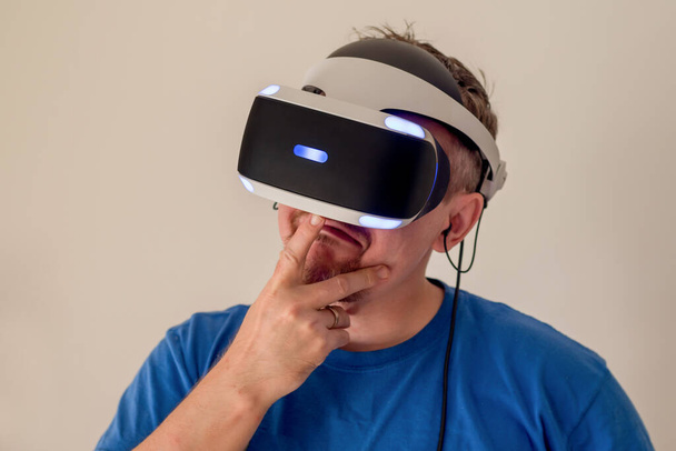 Milllenial bearded man wearing VR glasses headset . Virtual reality simulator technology. Gaming - Фото, изображение